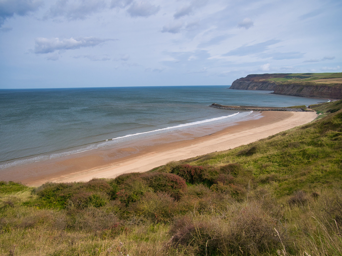 Cattersty Sands Beach and jetty, Skinningrove on the coast of the North York Moors, Yorkshire, UK, taken from the Cleveland Way coast path on a sunny day.